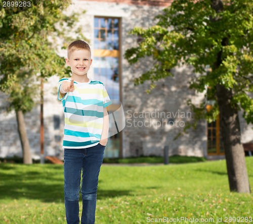 Image of smiling little boy pointing finger at you