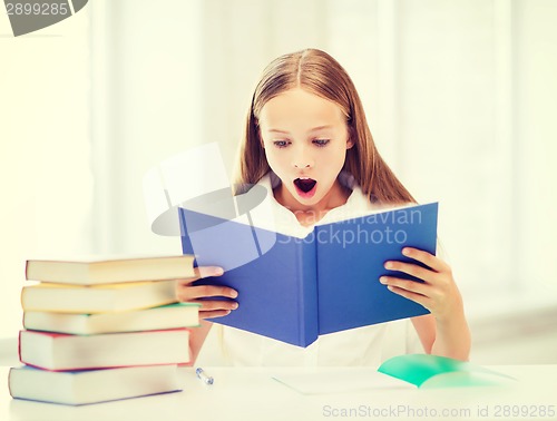 Image of girl studying and reading book at school