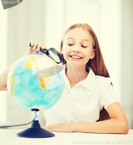 Image of child looking at globe with magnifier