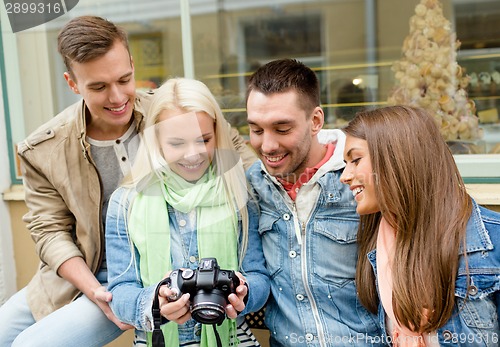 Image of group of smiling friends with digital photocamera