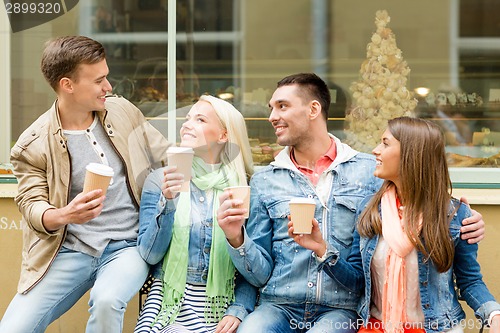 Image of group of smiling friends with take away coffee