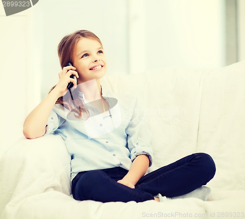 Image of smiling girl with smartphone at home