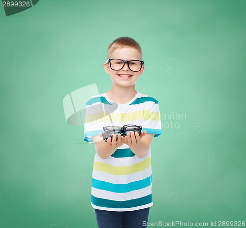 Image of smiling boy in eyeglasses holding spectacles