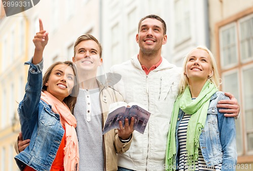 Image of group of friends with city guide exploring town