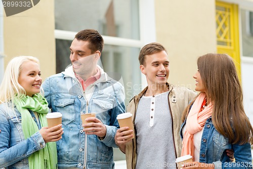 Image of group of smiling friends with take away coffee