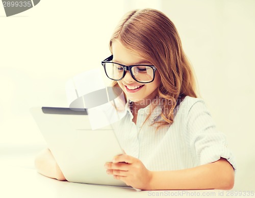 Image of smiling girl in glasses with tablet pc at school