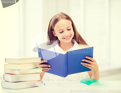 Image of girl studying and reading book at school