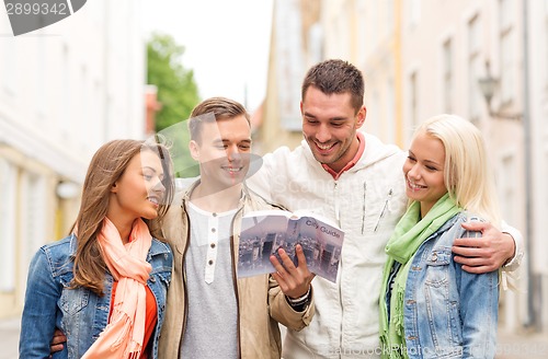 Image of group of friends with city guide exploring town