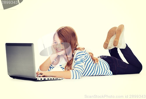 Image of smiling student girl with laptop computer lying