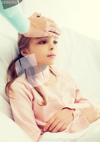 Image of ill girl child with thermometer and caring mother