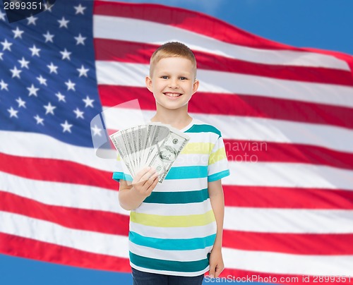 Image of smiling boy holding dollar cash money in his hand