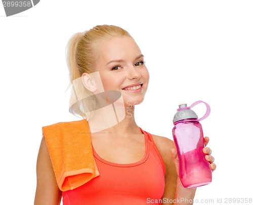 Image of smiling sporty woman with water bottle and towel