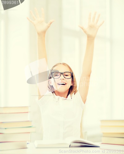 Image of girl with books and hands up