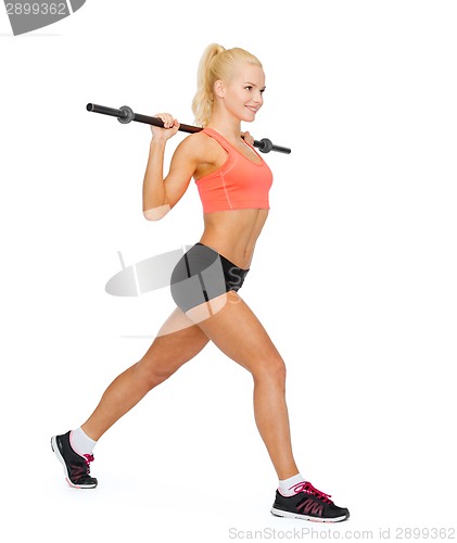 Image of smiling sporty woman exercising with barbell