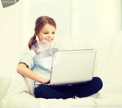 Image of smiling girl with laptop computer at home