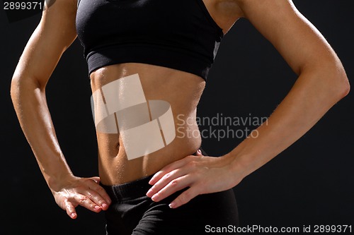 Image of close up of athletic female abs in sportswear