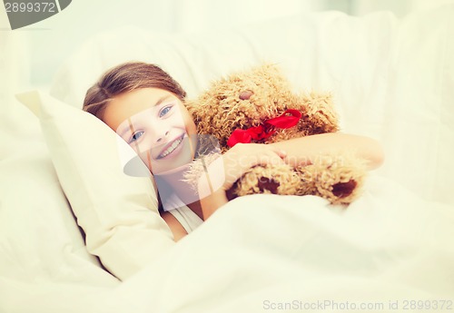 Image of little girl with teddy bear sleeping at home