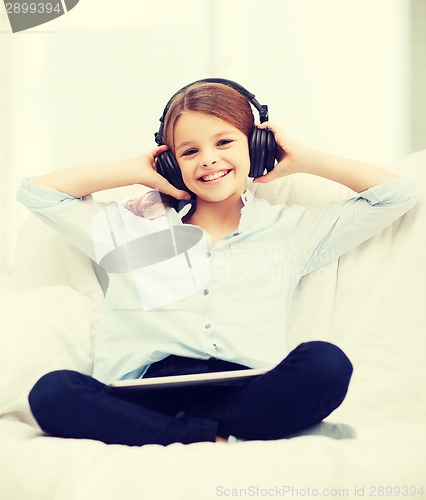Image of girl with tablet pc and headphones at home