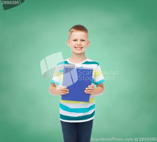 Image of smiling little student boy with blue book