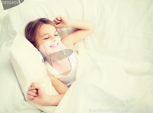 Image of smiling girl child waking up in bed at home