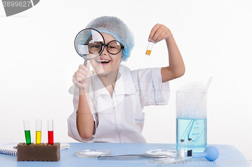 Image of Chemist with the powder and a magnifying glass