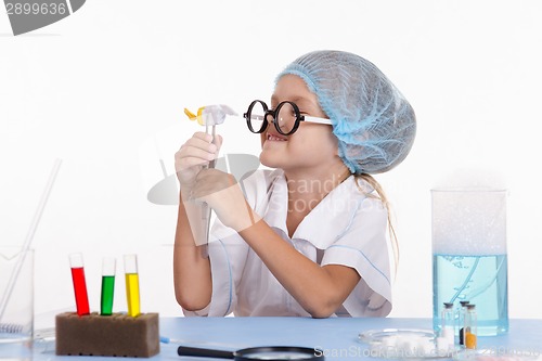 Image of Girl holding in tweezers candy