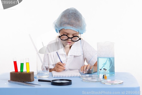 Image of Pharmacist in lab writing a notebook