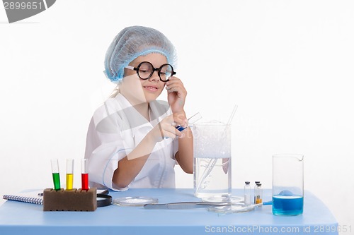 Image of Girl pouring blue liquid in flask