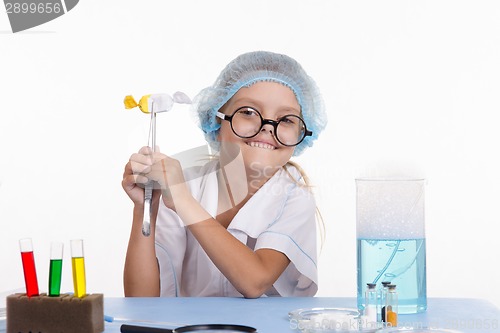 Image of Girl holding a chemist tweezers candy
