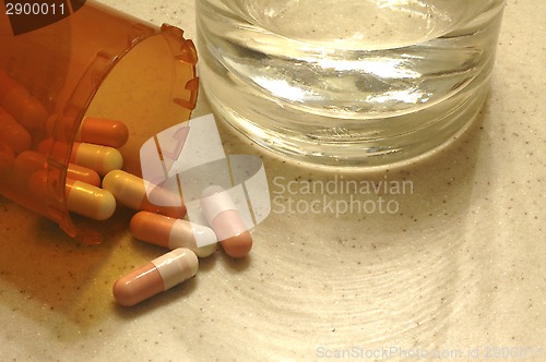 Image of Drug capsules with a glass of water