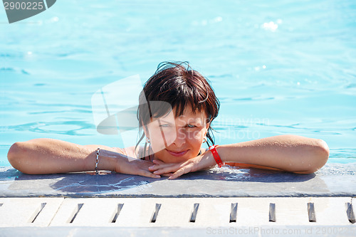 Image of smiling middle age woman relaxing in swimming pool