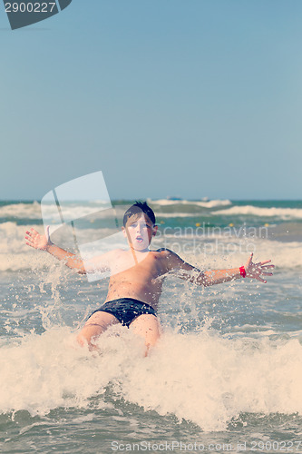 Image of Happy boy running and jumping at shallow sea water