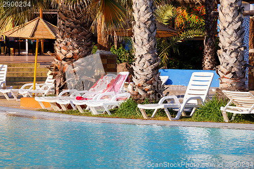 Image of sunloungers on swimming pool 