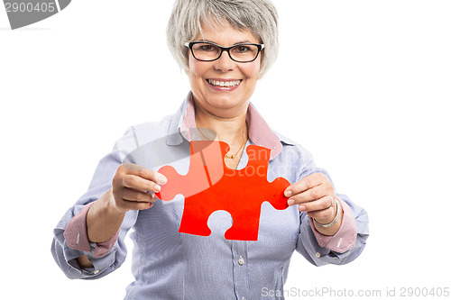 Image of Elderly woman holding a puzzle piece