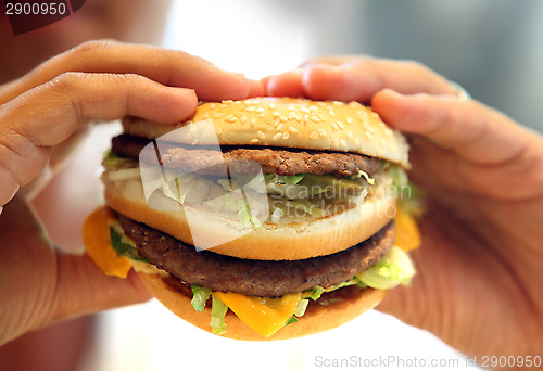 Image of man's hands, holding onto a burger