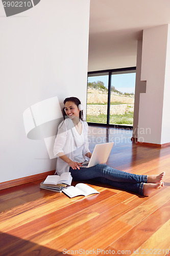 Image of relaxed young woman at home working on laptop