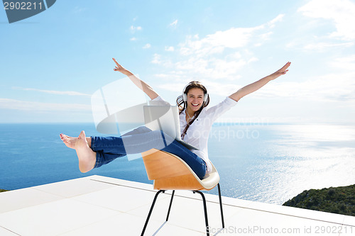 Image of relaxed young woman at home working on laptop