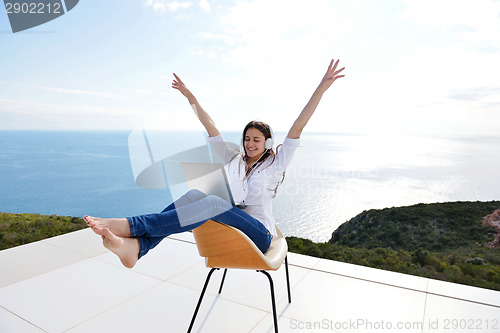 Image of relaxed young woman at home working on laptop