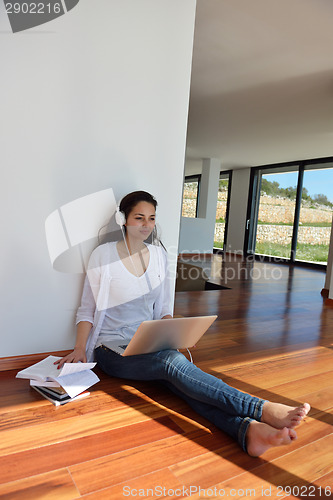 Image of relaxed young woman at home working on laptop
