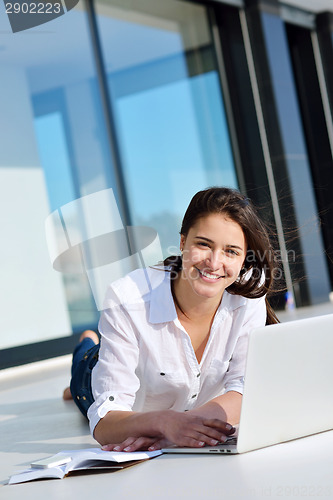 Image of relaxed young woman at home working on laptop computer