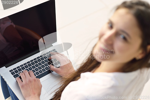 Image of relaxed young woman at home working on laptop computer