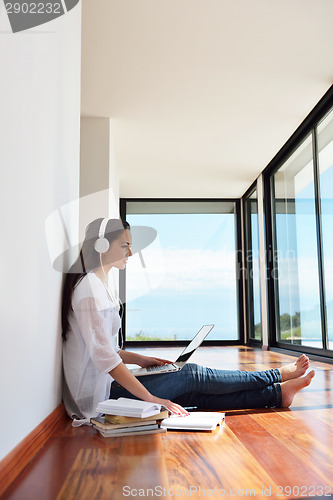 Image of relaxed young woman at home working on laptop
