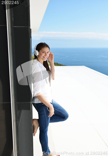 Image of girl listening to the music on white headphones