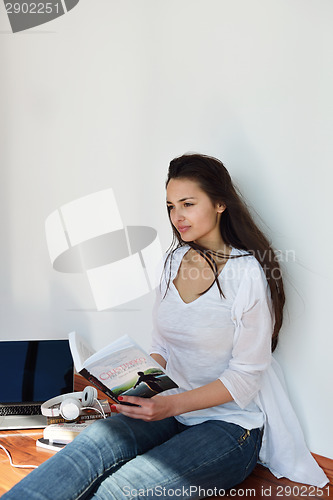 Image of relaxed young woman at home working on laptop