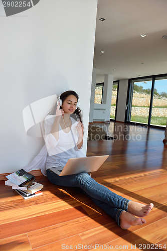 Image of relaxed young woman at home working on laptop