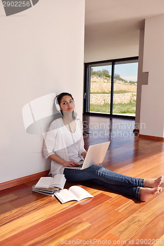 Image of relaxed young woman at home working on laptop