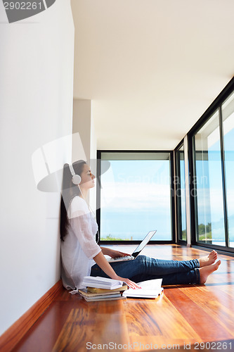 Image of relaxed young woman at home working on laptop