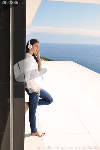 Image of girl listening to the music on white headphones