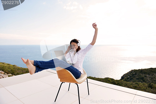 Image of relaxed young woman at home working on laptop