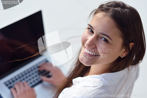 Image of relaxed young woman at home working on laptop computer